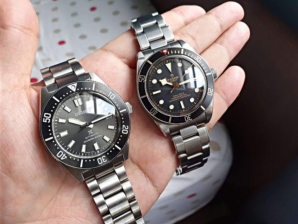 a pair of Omega watches on original metal bracelets