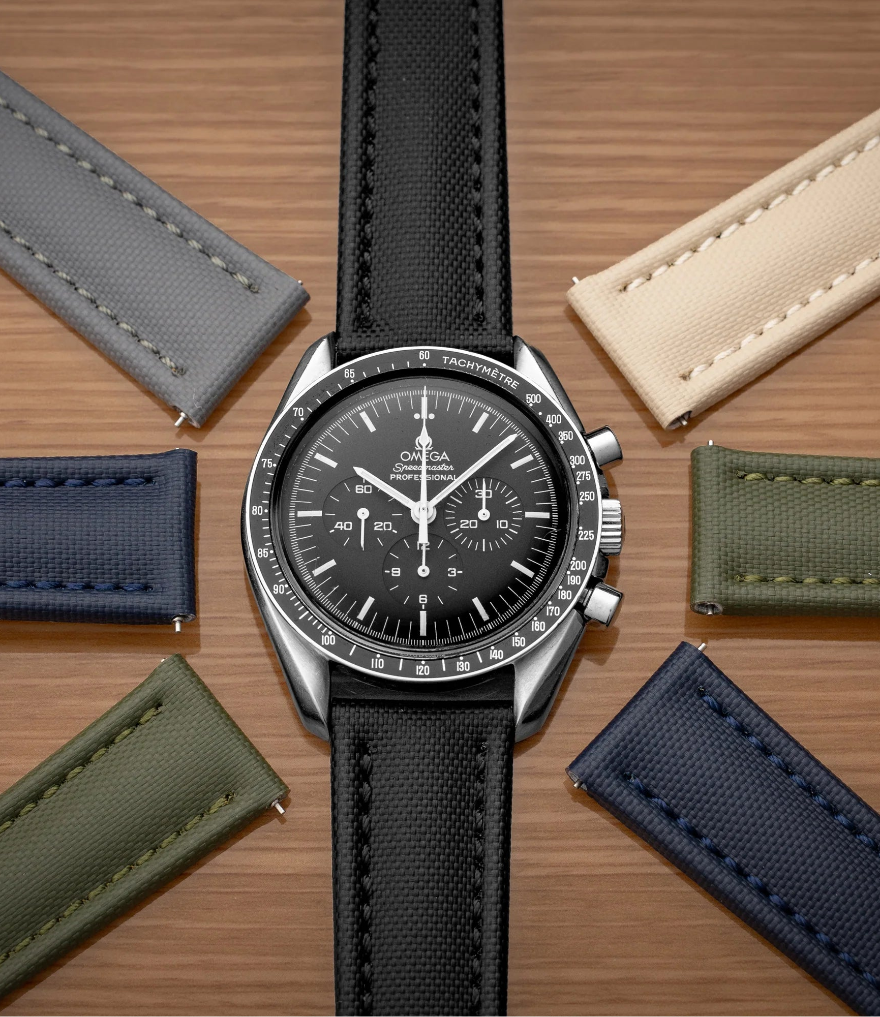 Watch with multiple leather straps on a wooden surface