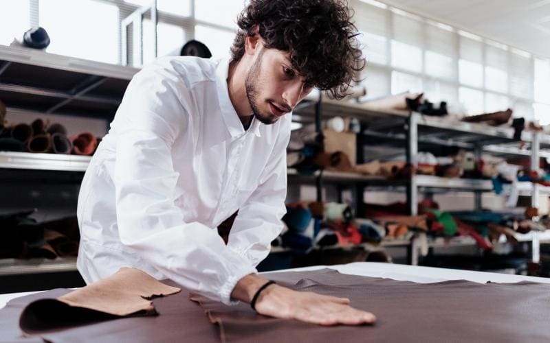 Leather strap being cut by hand