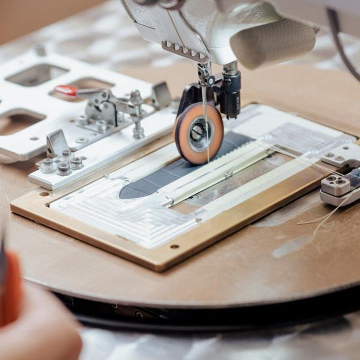 A stitching machine sewing a leather watch strap
