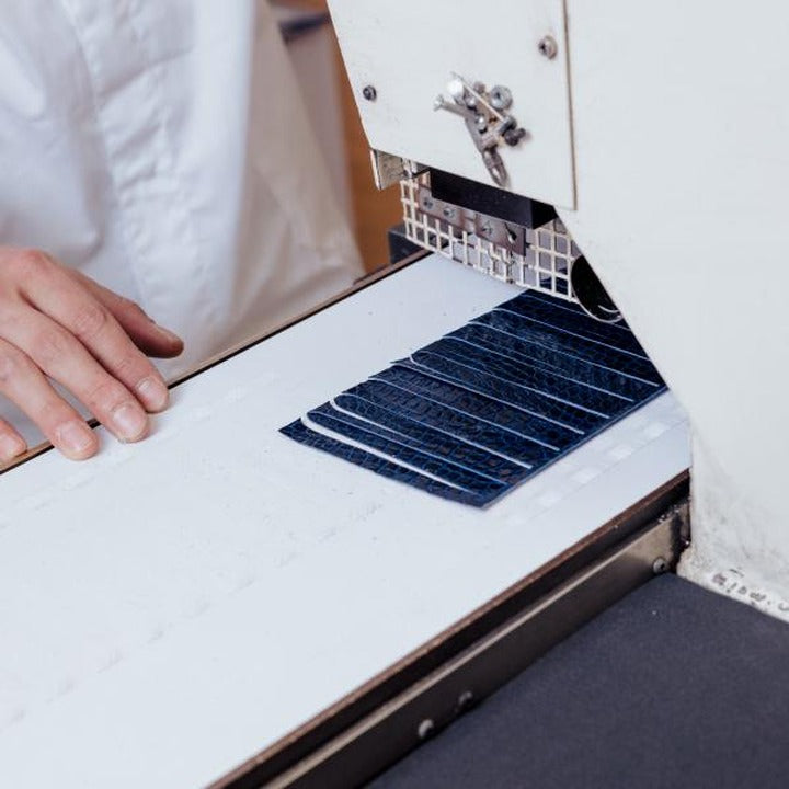 Cutting a textured exotic leather sheet on a strap press